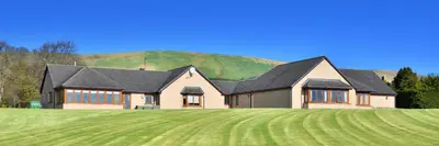 a house on a hill with a large green field at Peggyslea Farm B&B in Edinburgh