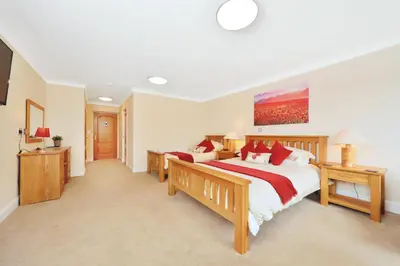 a large bedroom with two beds and a television at Peggyslea Farm B&B in Edinburgh