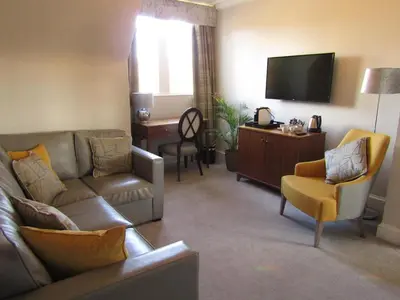 a living room with a couch and a flat screen tv at The Craigie Hotel in Penicuik