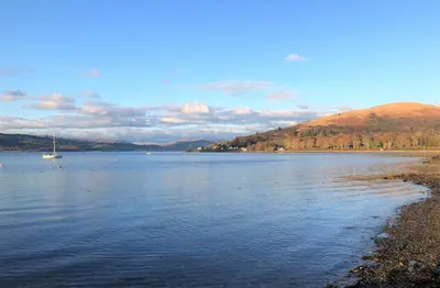 a large body of water with a boat in it at Glenbranter Cottage in Strachur
