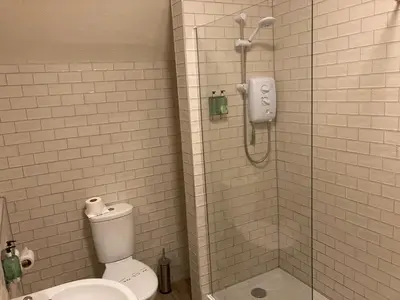 a bathroom with a toilet and a glass shower at Tullie Inn in Balloch