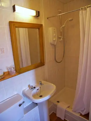 a bathroom with a sink and a shower with a mirror at Ardleigh House in Edinburgh