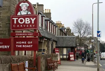 a building with a sign for a teddyagency and a home of the roast at Eagles Land in Edinburgh