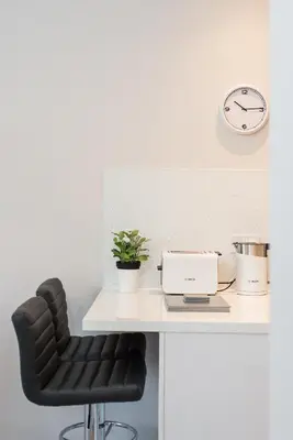 a desk with a chair and a clock on a wall at The New Westfield in Edinburgh