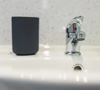 a bathroom sink with aaucet and a cell phone at The New Westfield in Edinburgh
