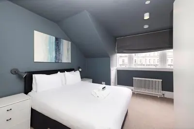 a bedroom with a large white bed and a window at JOIVY Spacious Apartment next to West End in Edinburgh