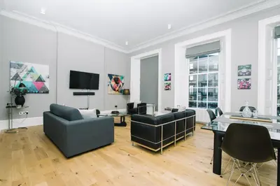 a living room with two couches and a tv at JOIVY Modern 1 bed flat next to Haymarket Station in Edinburgh
