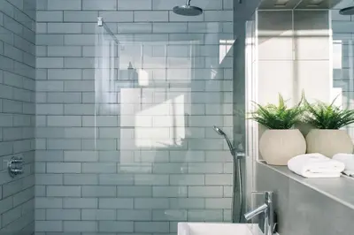 a bathroom with blue subway tiles and a sink at JOIVY Modern 1 bed flat next to Haymarket Station in Edinburgh