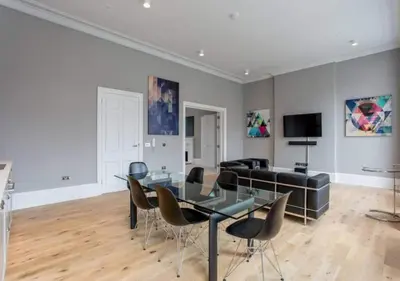 a dining room with a glass table and chairs at JOIVY Modern 1 bed flat next to Haymarket Station in Edinburgh