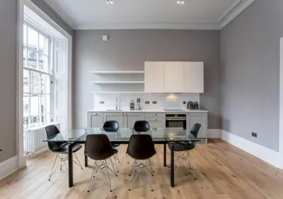 a kitchen with a dining room table and chairs at JOIVY Modern 1 bed flat next to Haymarket Station in Edinburgh
