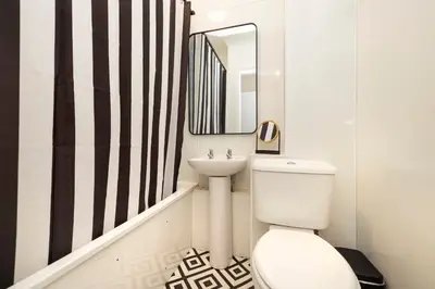 a bathroom with a white toilet and a sink at JOIVY Stylish Castle View Flat with Balcony in Edinburgh