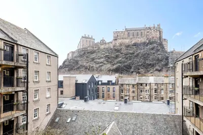 a view of a city with a castle in the background at JOIVY Stylish Castle View Flat with Balcony in Edinburgh