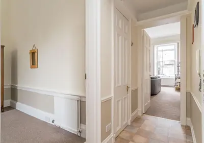 a hallway with white walls and an open door at Melville Street Apartment in Edinburgh
