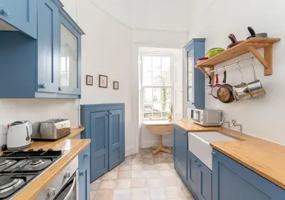 a kitchen with blue cabinets and a sink at Melville Street Apartment in Edinburgh