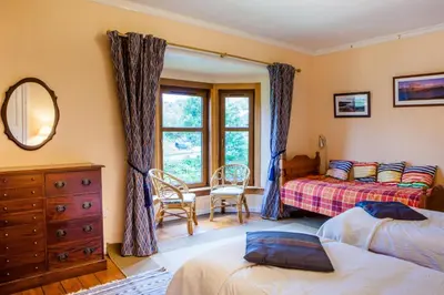 a bedroom with two beds and a mirror at Shelburne Lodge in Cairnbaan