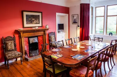 a dining room with a table and a fireplace at Shelburne Lodge in Cairnbaan