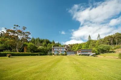 a large grass field in front of a house at Crispie House in Kilfinan
