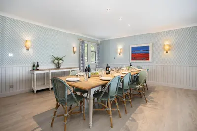 a dining room with a long table and chairs at Crispie House in Kilfinan