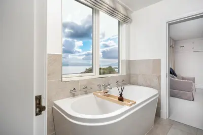 a bath tub in a bathroom with a window at Crispie House in Kilfinan