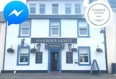 a white building with a sign that reads harpoon lights at Harbourlights Accomodation in Irvine
