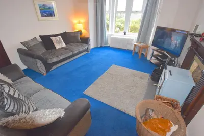 a living room with a couch and a tv at Lettermay House in Lochgoilhead