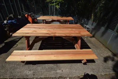 two wooden picnic tables sitting next to a fence at Lettermay House in Lochgoilhead