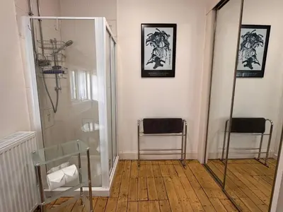 a bathroom with a shower and two chairs in a room at The Sheiling in Saint Fillans