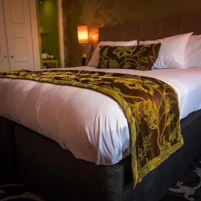 a bed with a blanket on it in a room at Hotel Indigo Glasgow by IHG in Glasgow
