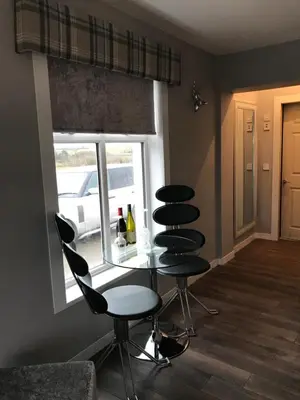 a room with two chairs and a table and a window at Carriage Cottage Hot Tub in Beith
