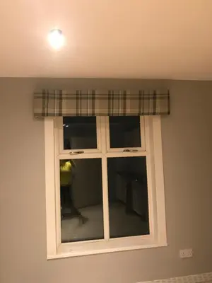 a window with a plaid curtain in a room at Carriage Cottage Hot Tub in Beith
