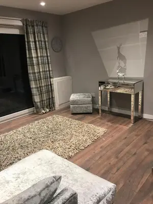 a living room with a couch and a table at Carriage Cottage Hot Tub in Beith
