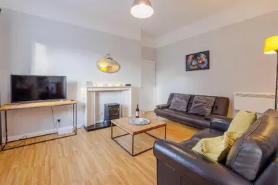 a living room with a couch and a tv at Linlithgow Apartment in Linlithgow
