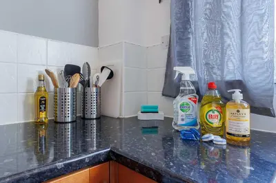 a kitchen counter with bottles of cleaning products on it at Linlithgow Apartment in Linlithgow