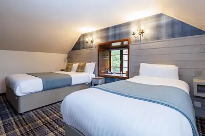 a hotel room with two beds and a window at Village Inn in Arrochar