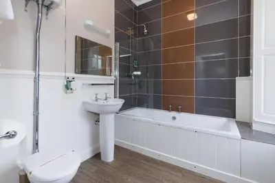 a bathroom with a toilet a sink and a bath tub at Village Inn in Arrochar