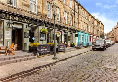 a cobblestone street in a city with buildings at Luxury apartment, Stafford Street in Edinburgh