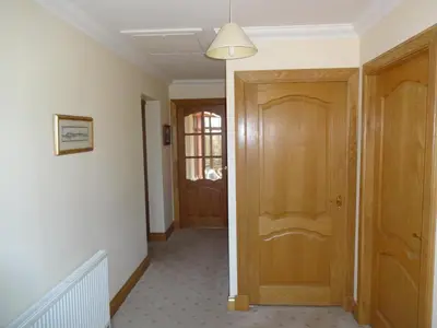 a hallway with a wooden door in a house at Wester Muirhouse in Linlithgow