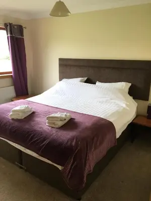 a bed with two towels on top of it at Wester Muirhouse in Linlithgow