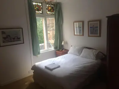 a bedroom with a white bed and a window at Newhall in Glasgow