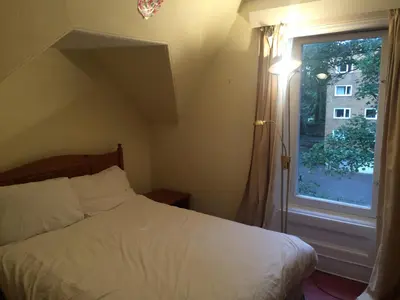 a bedroom with a white bed and a window at Newhall in Glasgow
