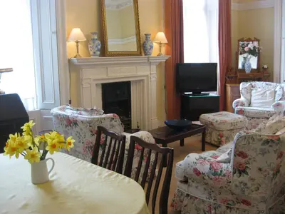 a living room with a table and chairs and a fireplace at Newhall in Glasgow