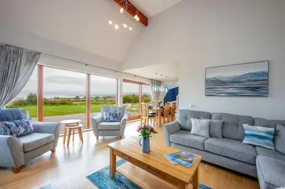 a living room with a couch and chairs and a table at Seabank Lodge in Oban