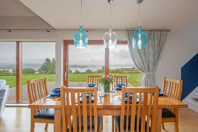 a dining room with a wooden table and chairs at Seabank Lodge in Oban