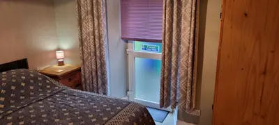 a bedroom with a window with a bed and a lamp at Millhill St Dunfermline in Dunfermline