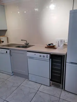 a kitchen with white appliances and a sink at The Greannan Lower Self catering apartment in Blackwaterfoot