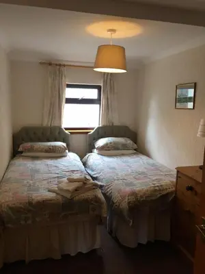 a bedroom with two beds and a window at The Greannan Lower Self catering apartment in Blackwaterfoot