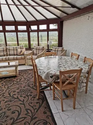 a patio with a table and chairs and a couch at The Greannan Lower Self catering apartment in Blackwaterfoot