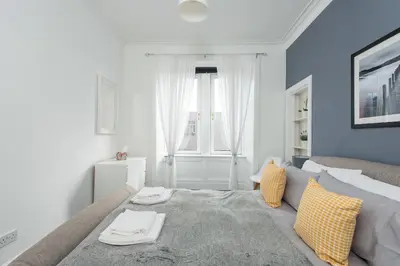 a bedroom with a large bed and a window at The Roseburn Apartment in Edinburgh