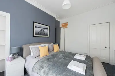 a bedroom with a large bed and a couch at The Roseburn Apartment in Edinburgh