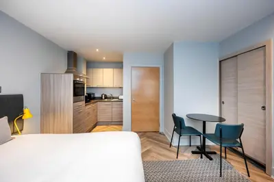a bedroom with a bed and a table and chairs at Staycity Aparthotels Edinburgh West End in Edinburgh